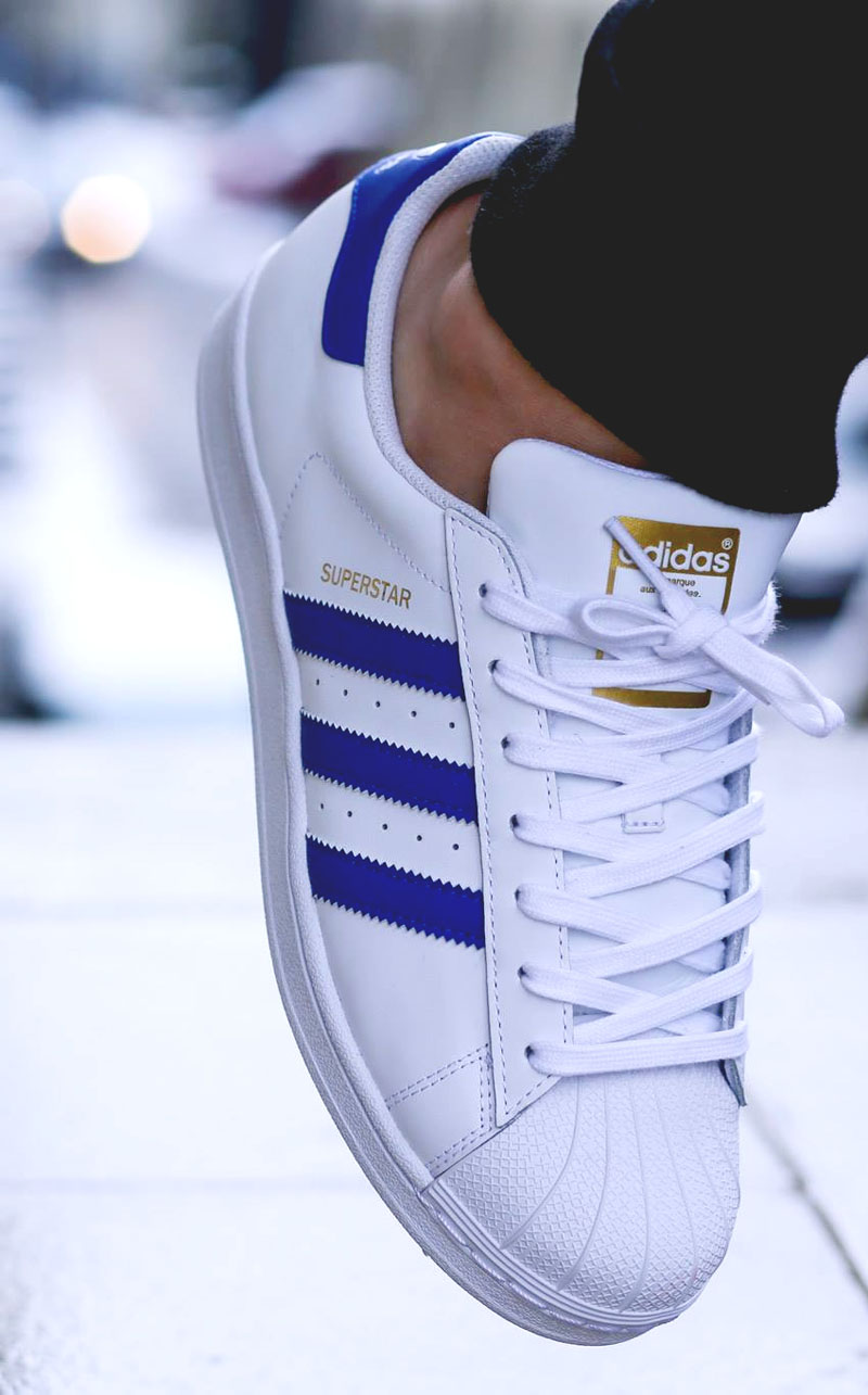 white adidas shoes with blue stripes